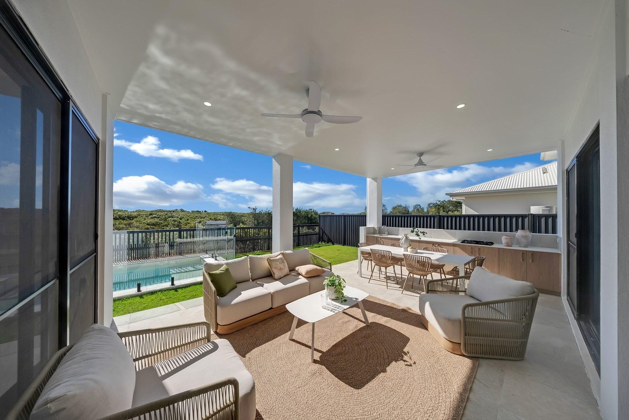 Covered outdoor living area overlooking a pool